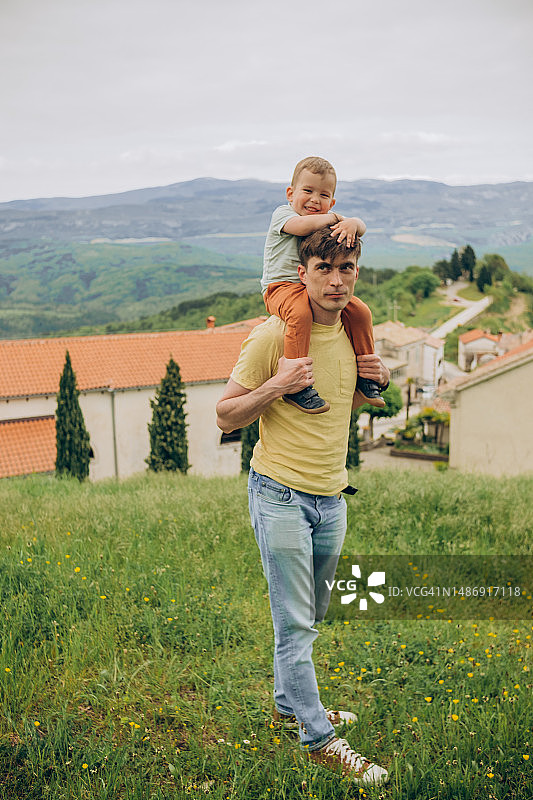 幸福家庭：宝宝在爸爸的脖子上，一起在户外散步图片素材