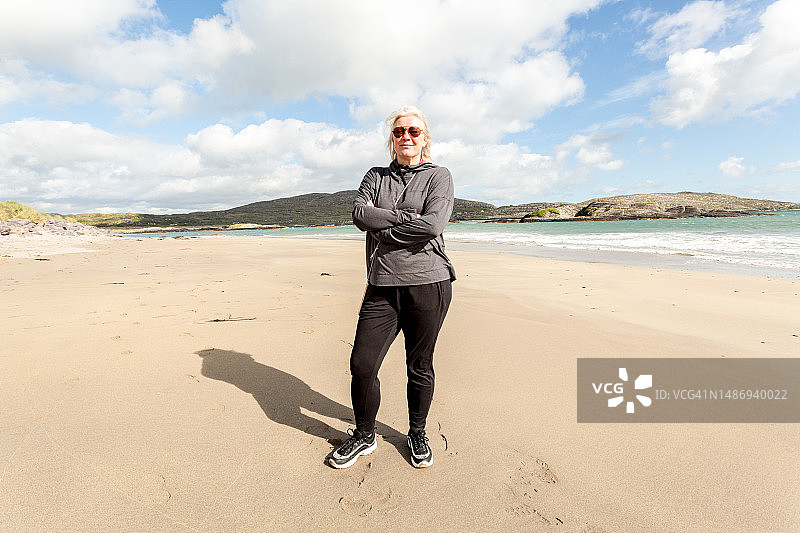 中年妇女站在空旷的沙滩上图片素材