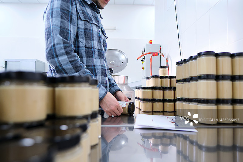 纯素食品厂工人打印标签上的到期日期图片素材