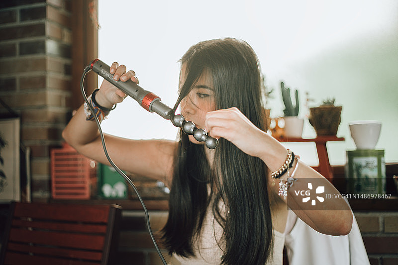 女性使用卷发棒图片素材