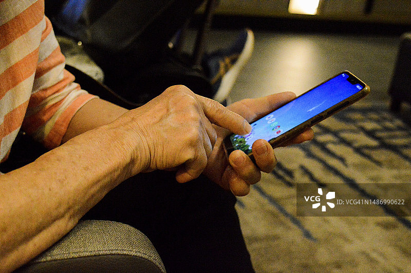 年长的女人使用智能手机图片素材