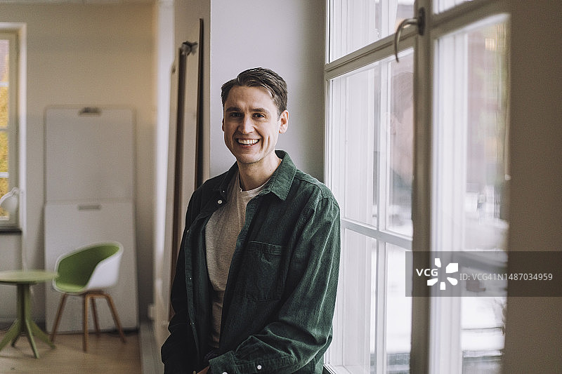 在创新实验室靠窗而立的快乐男博士生图片素材