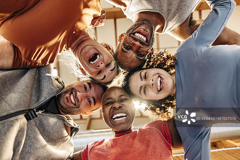 运动场上快乐的男女运动员拥抱在一起的仰视照片图片素材
