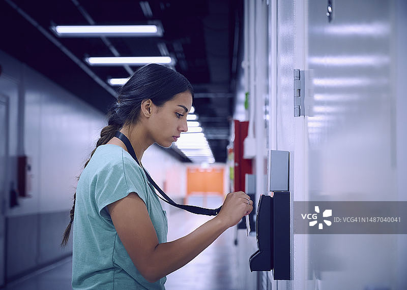 在数据中心使用安全卡进入房间的女人图片素材