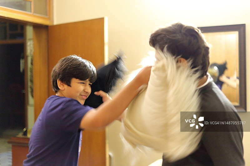 在家中进行枕头大战的青少年朋友图片素材