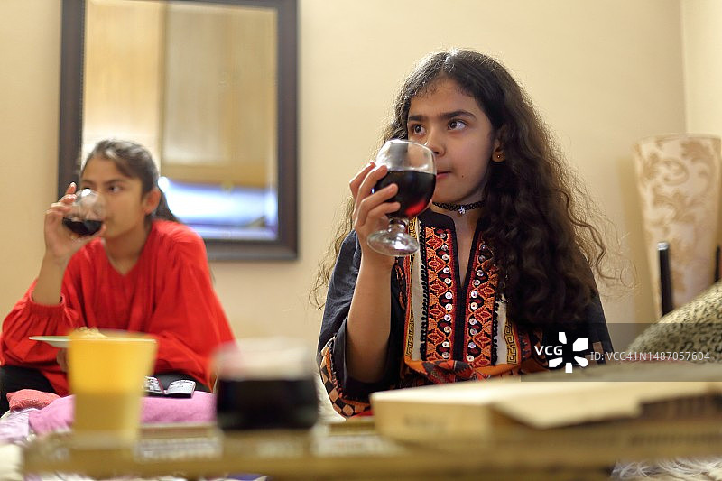两个女孩在客厅里喝冷饮图片素材