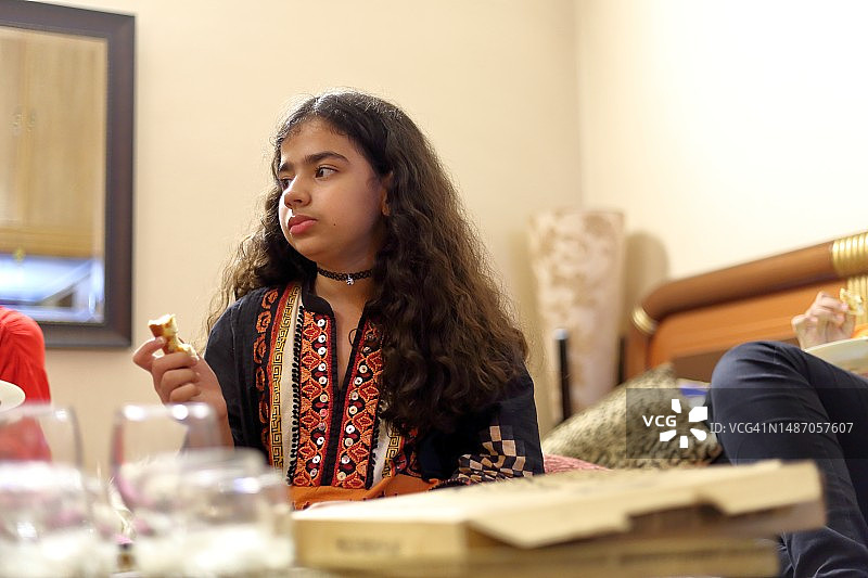 小女孩在客厅里吃披萨图片素材