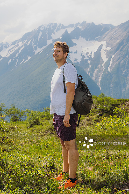 快乐的男人在挪威的Sunnmore阿尔卑斯山上思考徒步旅行图片素材