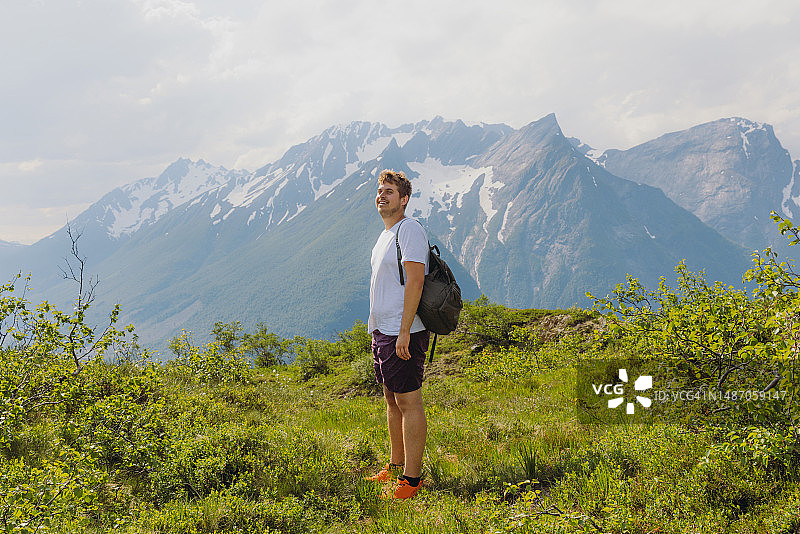 快乐的男人在挪威的Sunnmore阿尔卑斯山上思考徒步旅行图片素材