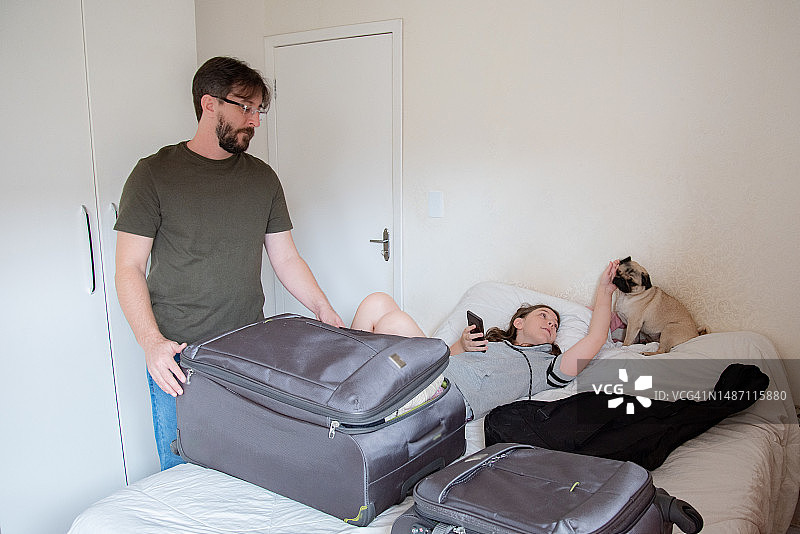 父亲、儿子和小巴哥犬制作旅行包图片素材