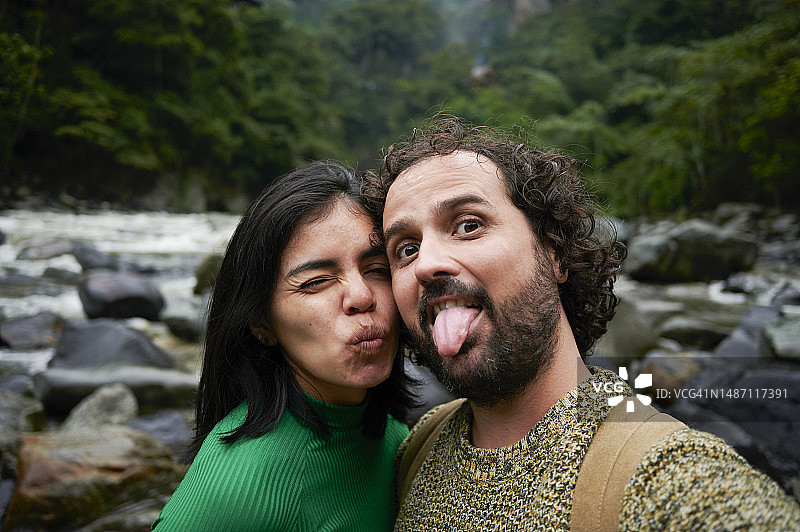 情侣在森林景观和河流中自拍图片素材