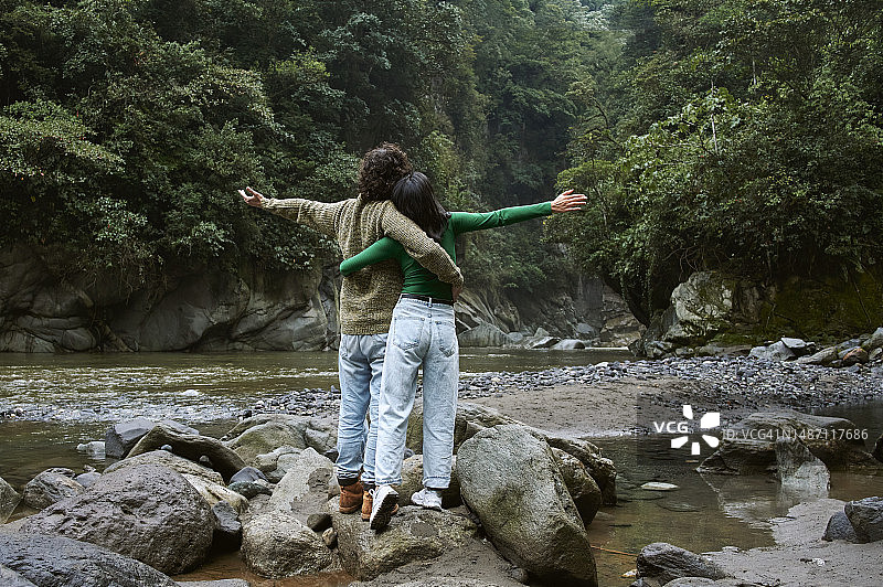 在厄瓜多尔自然景观中举起双臂的情侣图片素材