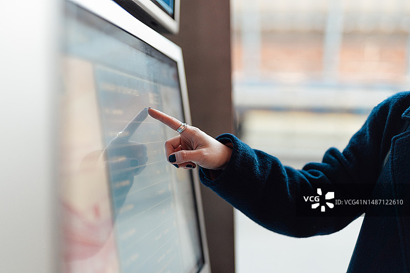 女性在自动售票机上购买火车票的手部特写图片素材
