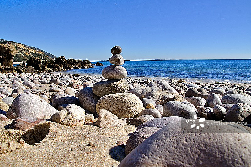 晴朗蓝天下海滩上的鹅卵石特写图片素材