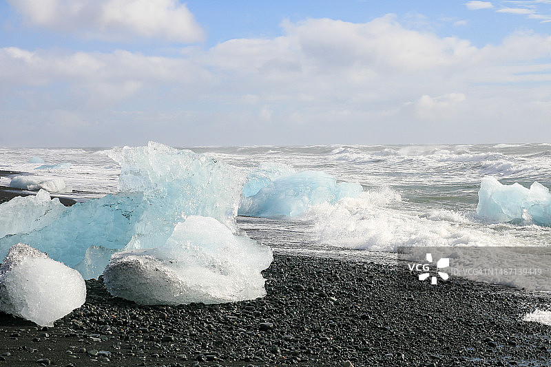 冰岛黑色沙滩上的巨型冰块图片素材