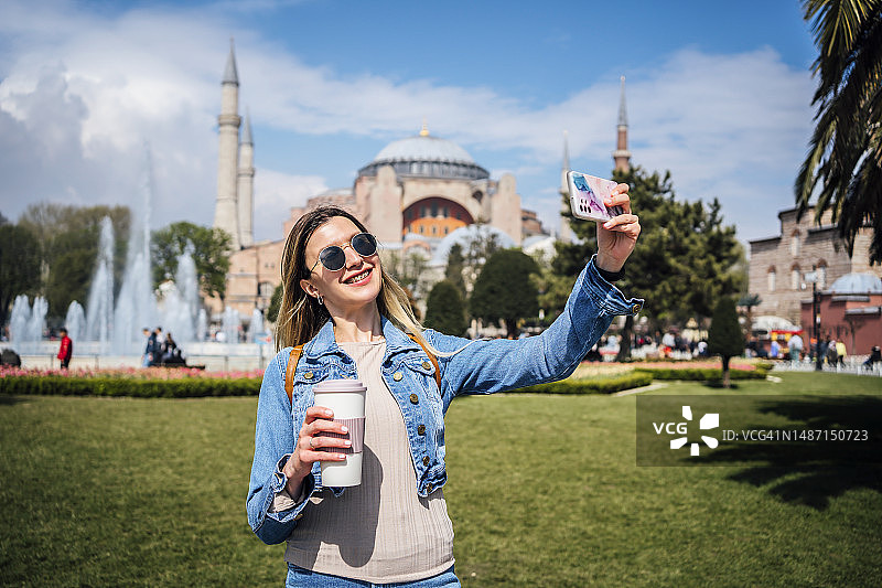 年轻女子在伊斯坦布尔圣索菲亚大教堂前自拍图片素材