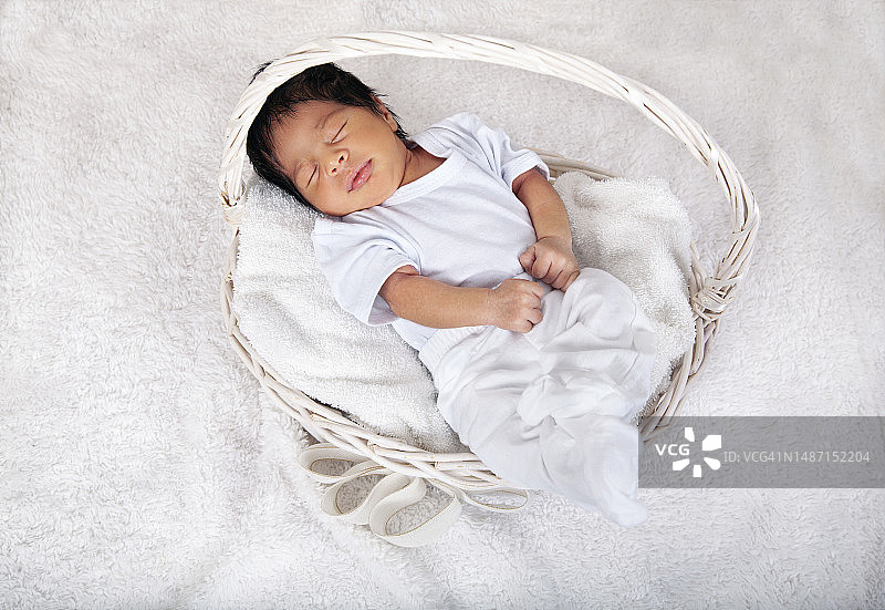 裹在毯子里睡在篮子里的非裔美国新生男婴图片素材