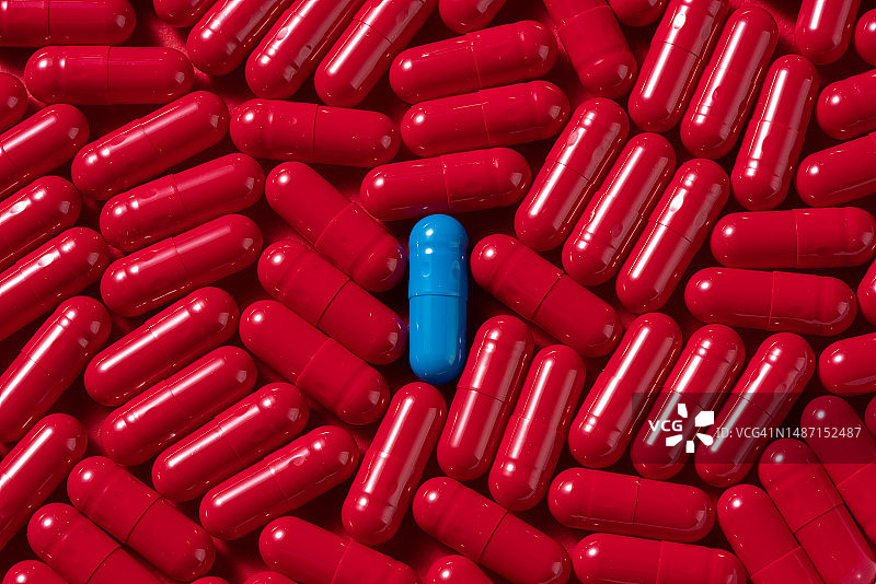 从红色胶囊中脱颖而出的蓝色胶囊图片素材