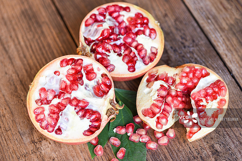 石榴与切开的半个石榴，木桌背景图片素材