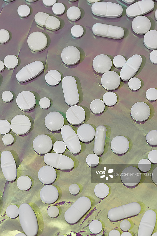 紫色背景上的各色药丸和平板电脑俯视图图片素材