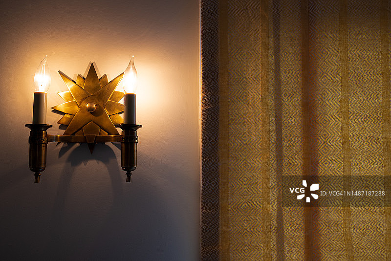 昏暗房间内照明的双黄铜壁灯图片素材