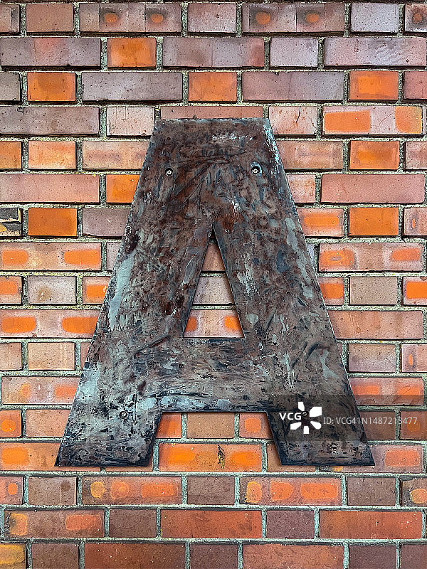 砖墙上的金属单字母A图片素材