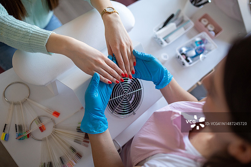 美甲店员工检查顾客的指甲图片素材