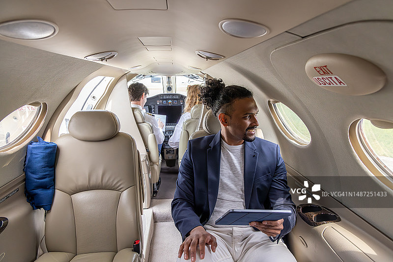 年轻商人在私人飞机上使用平板电脑工作图片素材
