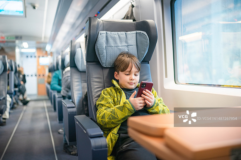 乘坐火车时使用手机的儿童乘客图片素材