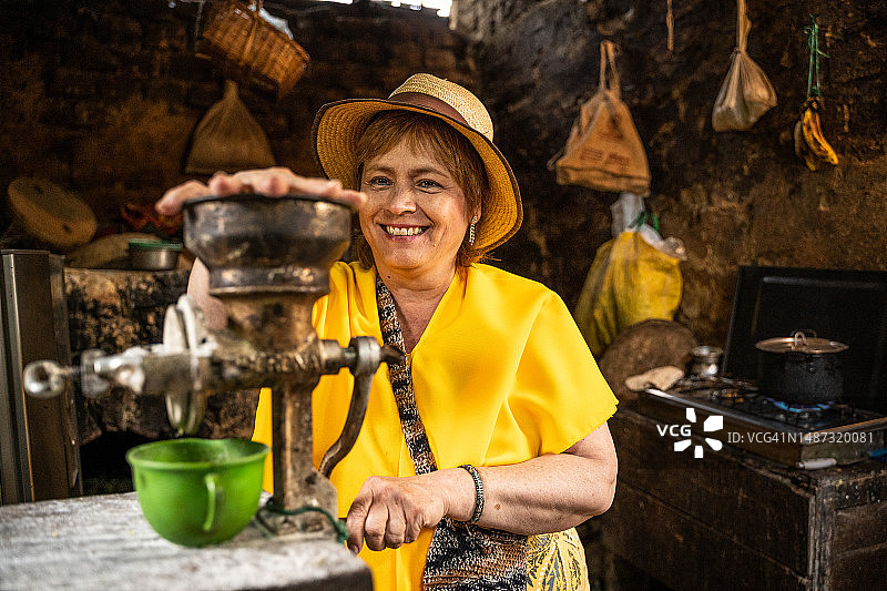 中年妇女在农舍磨咖啡图片素材
