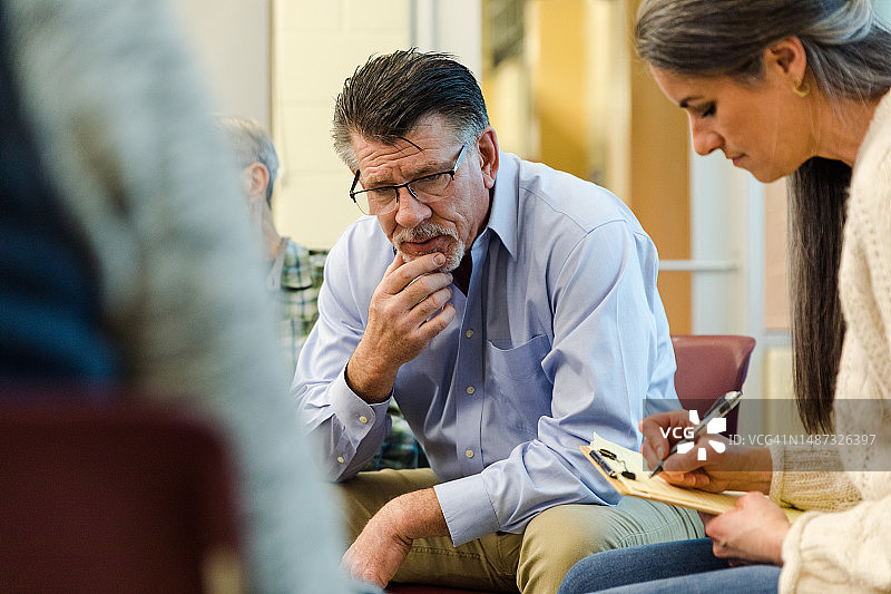 女心理健康顾问在成熟男人讲话时做笔记图片素材