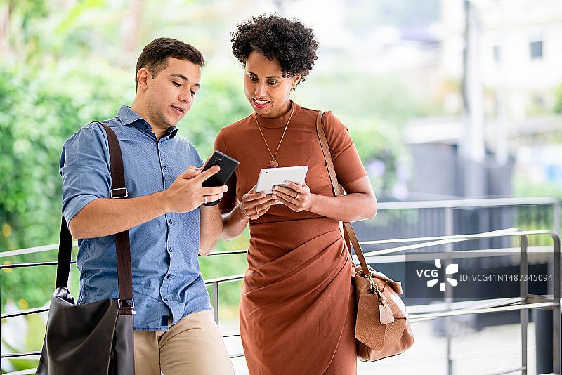 在办公室外通过无线方式共享文件的年轻商务人士图片素材