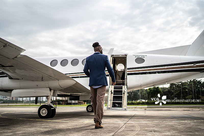中年男子走向机场机库内飞机的背影图片素材