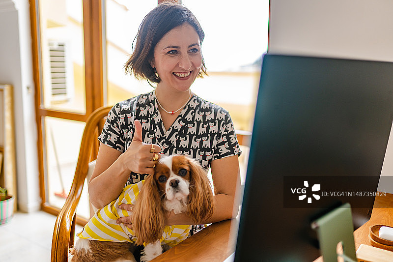 与她的狗病人进行在线兽医咨询的女兽医图片素材