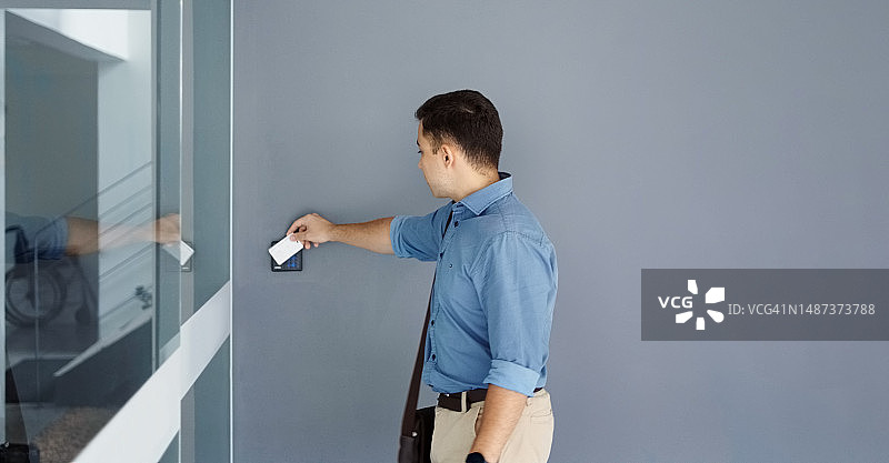 年轻男人用钥匙卡打开办公室的门图片素材