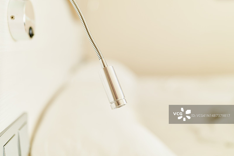 带柔性颈部的现代铝制LED工作室灯，安装在房间的白色墙壁上图片素材