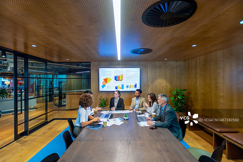 商务演示或研讨会上在会议室桌旁会面和工作的多元化人群图片素材