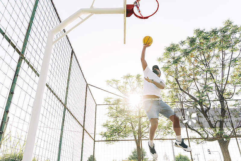 亚洲男人在运动场训练，投篮图片素材