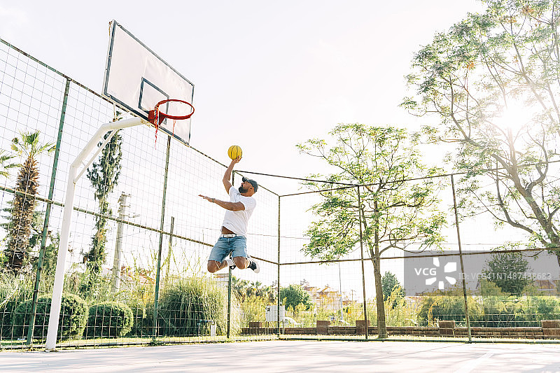 亚洲男人在运动场训练，投篮图片素材