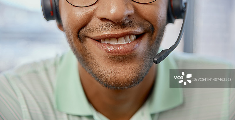 呼叫中心男客服戴耳机进行在线咨询的嘴部特写图片素材