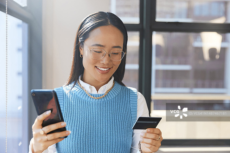 办公室场景，快乐的亚洲女人用手机信用卡在金融科技上进行在线投资图片素材