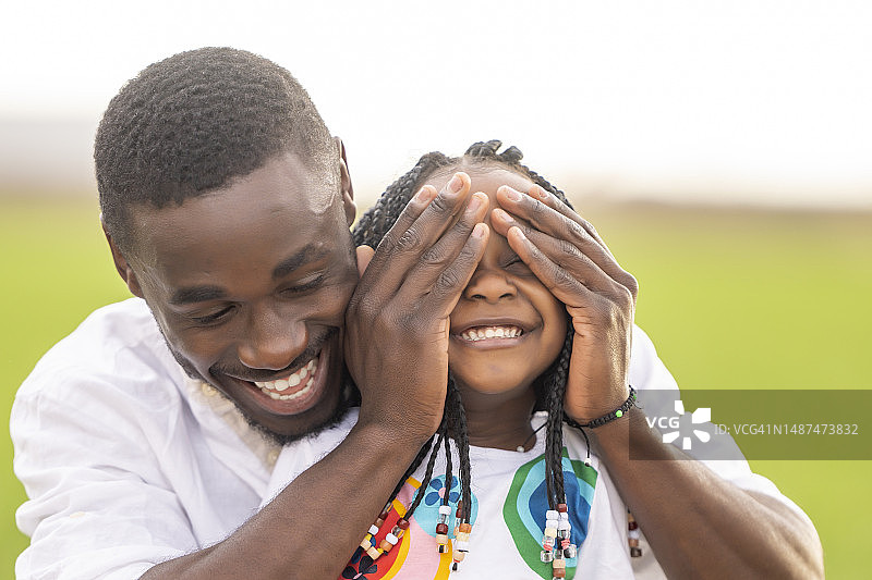 幸福父亲蒙着女儿的眼睛玩耍图片素材