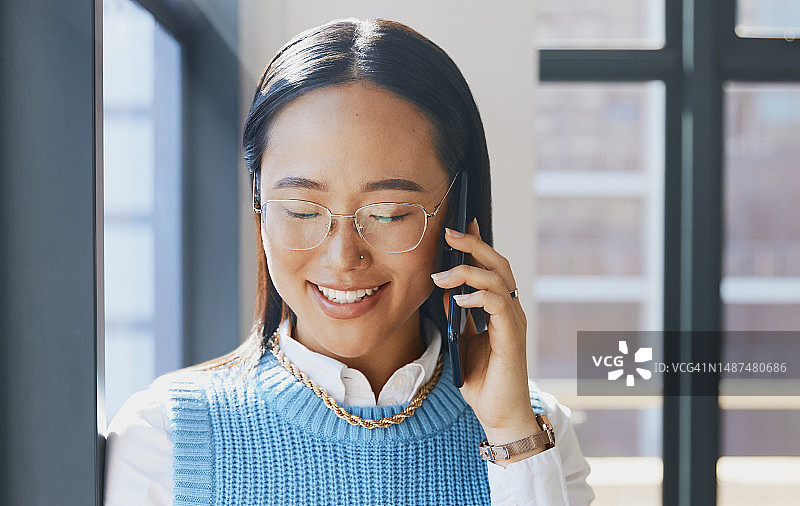 亚洲女商人：在办公室用手机进行沟通，工作时倾听和交谈图片素材