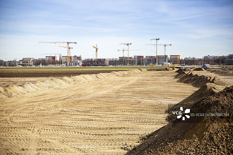 德国巴伐利亚慕尼黑：为建筑工地准备的沙地，背景是工业起重机图片素材