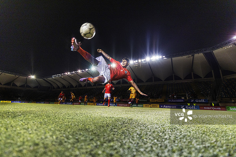 男运动员在空中精彩倒钩踢足球的广角照片图片素材