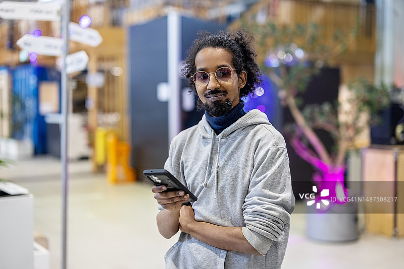 在创客空间使用手机的创意男士肖像图片素材