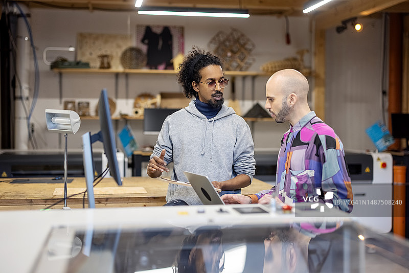 两个男人在创意工坊讨论项目图片素材
