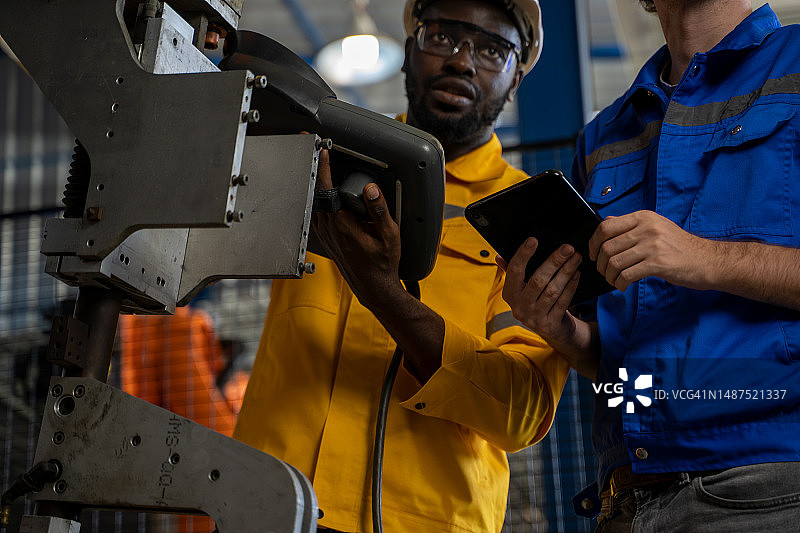 机器手臂技术员在金属工厂车间工作图片素材