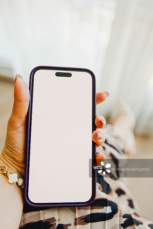 女人手持白色屏幕智能手机图片素材