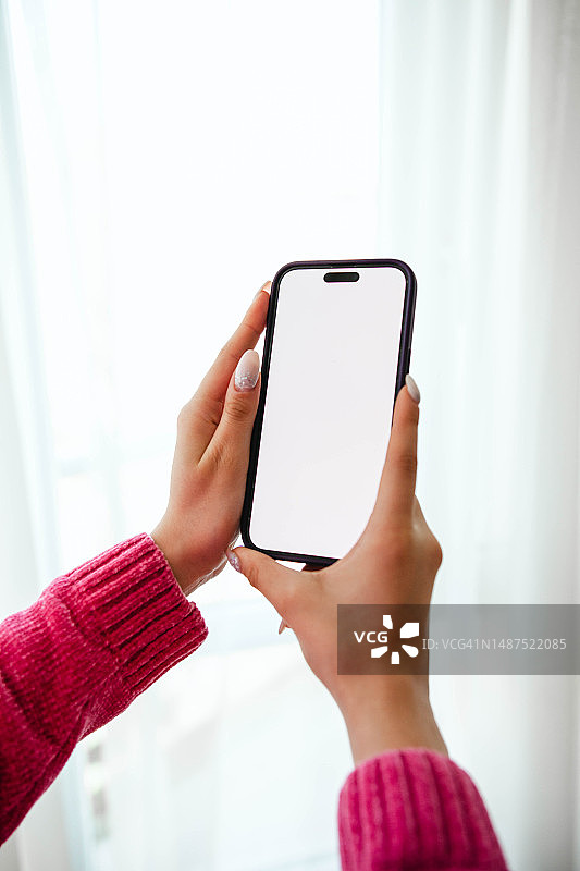 女人手持白色屏幕的智能手机图片素材